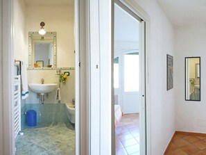 Une salle de bain avec un lavabo, un miroir et une douche.