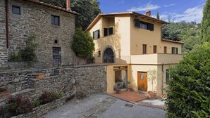 A stone building with a yellow house adjacent to it.
