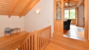 Ein Holzinnenraum mit Treppe, einem kleinen Tisch und einem Stuhl.