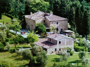 A large stone building with a tiled roof, surrounded by lush greenery and trees. - Romantic Farmhouse near Medieval Village of Montaione (Montaione)
