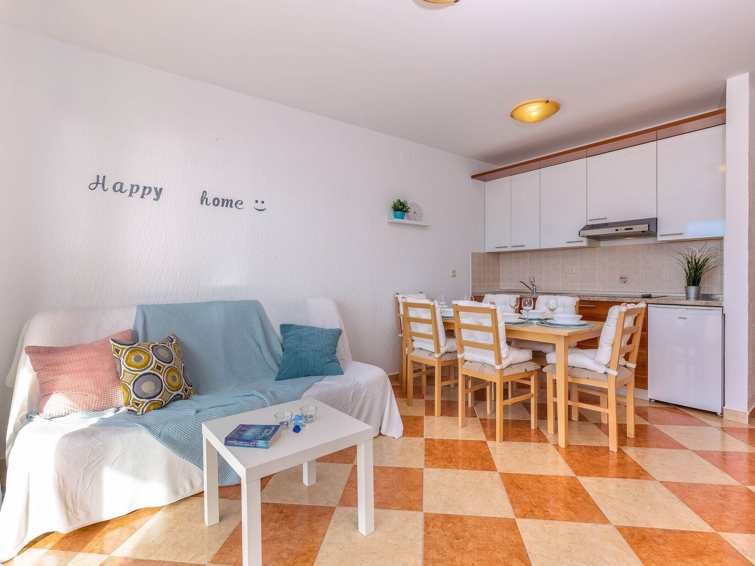 Una sala de estar acogedora con un sofá, una mesa de centro y un comedor con sillas y una mesa.
