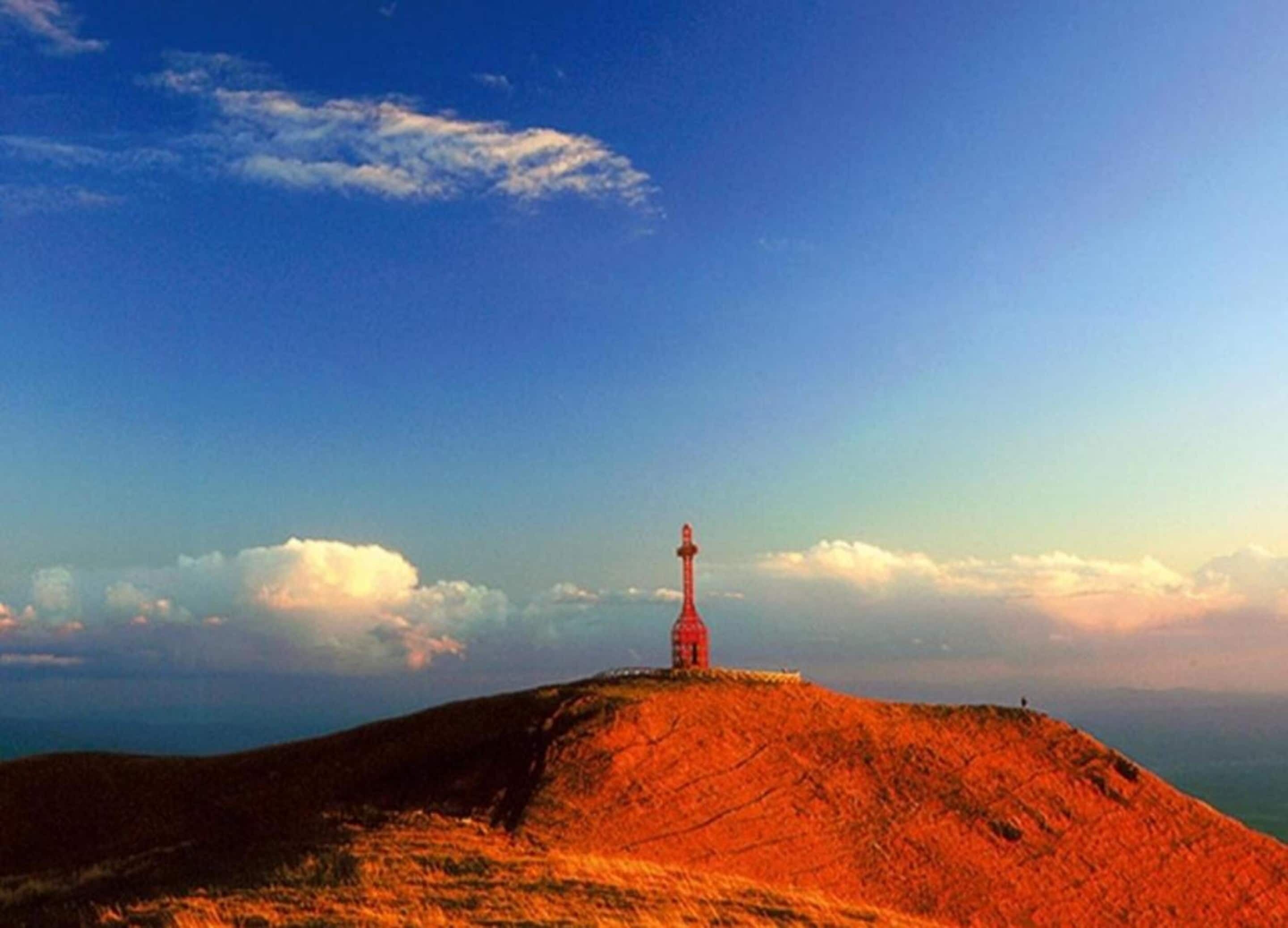 A lighthouse on a hill with a clear sky.