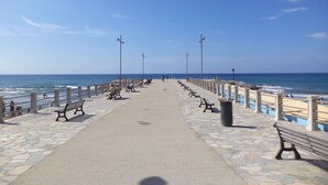 A paved walkway with benches and railings along a beach. - Small House in the Hills for Beautiful Walks Near the Sea (Stellanello)