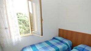 A small, single-room accommodation with a bed and a window. - Sun Drenched Seaside Holiday Home near Venice (Rosolina)
