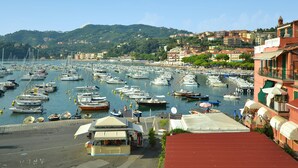 A marina with numerous boats docked, a small kiosk, and buildings with balconies in the background. - Holiday Home in Sesta Godano With BBQ (Sesta Godano)