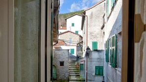 A narrow street with stone buildings, green shutters, and a visible staircase leading to a higher level. - Holiday Home in Sesta Godano With BBQ (Sesta Godano)