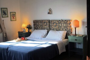 A neatly made bed with white linens, a tray with breakfast items, and two bedside lamps on nightstands.