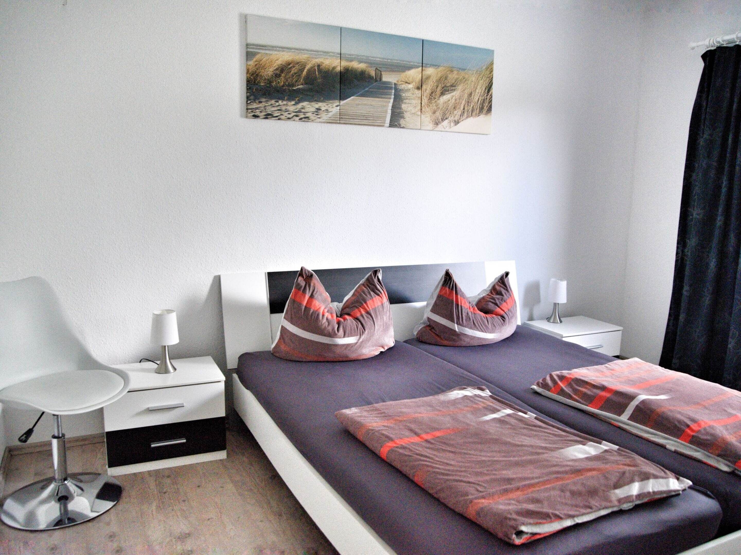 Een hotelkamer met een bed, nachtkastjes, een bureau en een stoel.