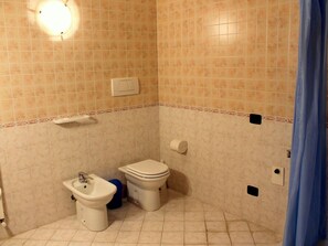 A small bathroom with a toilet, bidet, and sink.