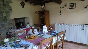 Ein Essbereich mit Tisch für zwei Personen, Kamin und Bücherregal.