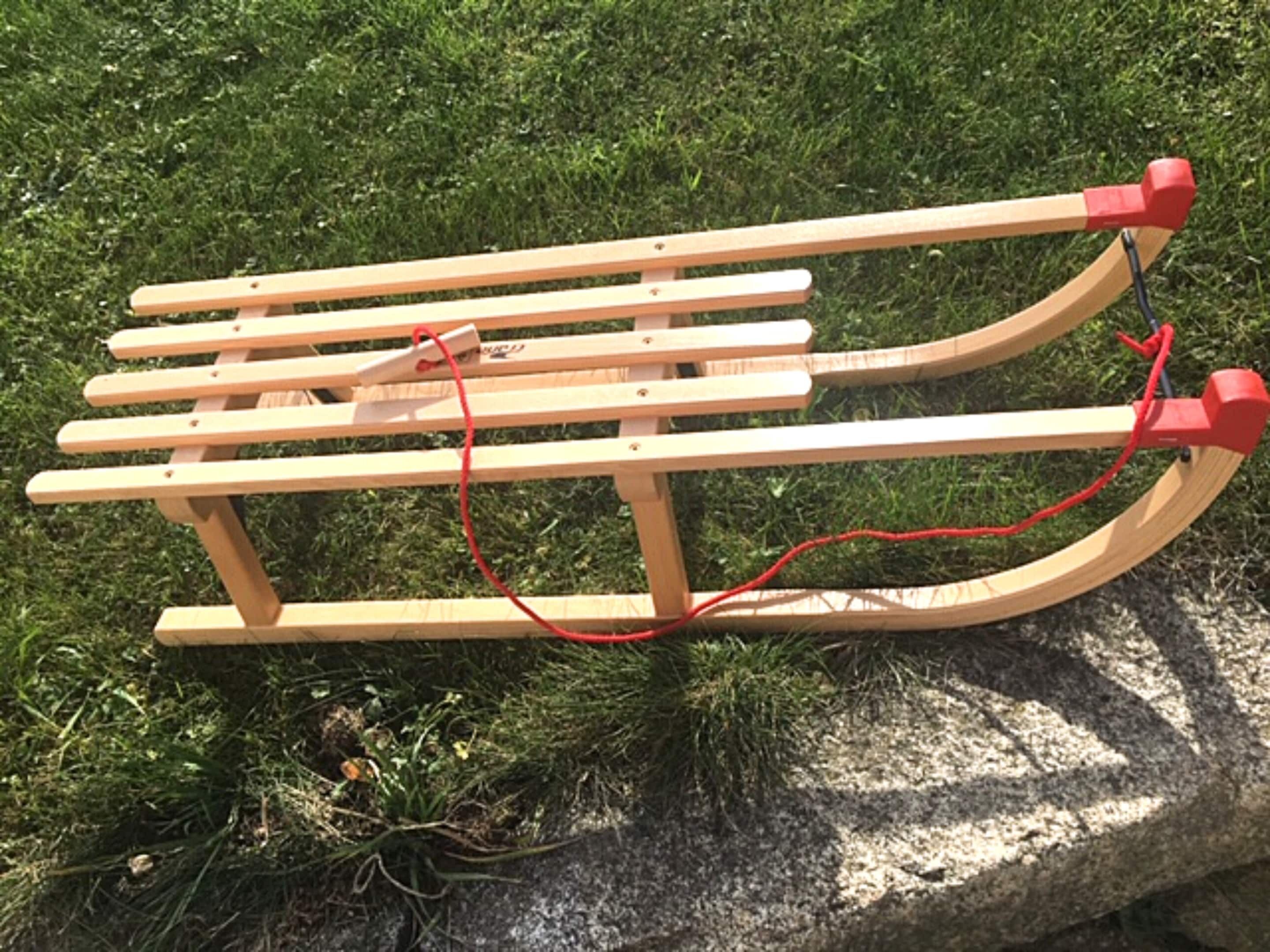A wooden bench with a red rope.