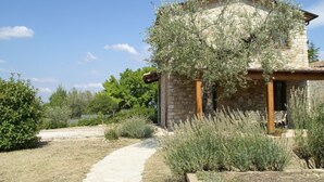 A stone house with a chimney, surrounded by a garden with lavender and other plants. - Villa in Umbertide With Pool and Garden (Umbertide)