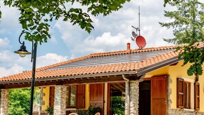 A house with a tiled roof, stone pillars, and wooden shutters. - Cottage in Tuscany With Private Pool (Montecatini Terme)