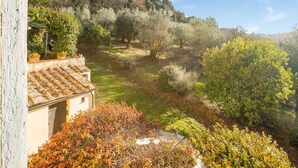 A traditional building with a tiled roof and a garden with various shrubs and trees. - Holiday Home With Vineyard Vibes (San Casciano in Val di Pesa)
