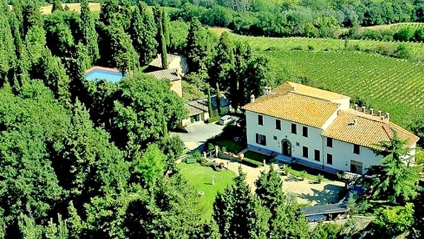 A large, white building with a tiled roof surrounded by lush greenery and vineyards. - Holiday Home With Vineyard Vibes (San Casciano in Val di Pesa)