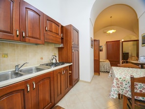 Enjoy meals in the kitchen with a stainless steel sink and adjacent dining area with a table.