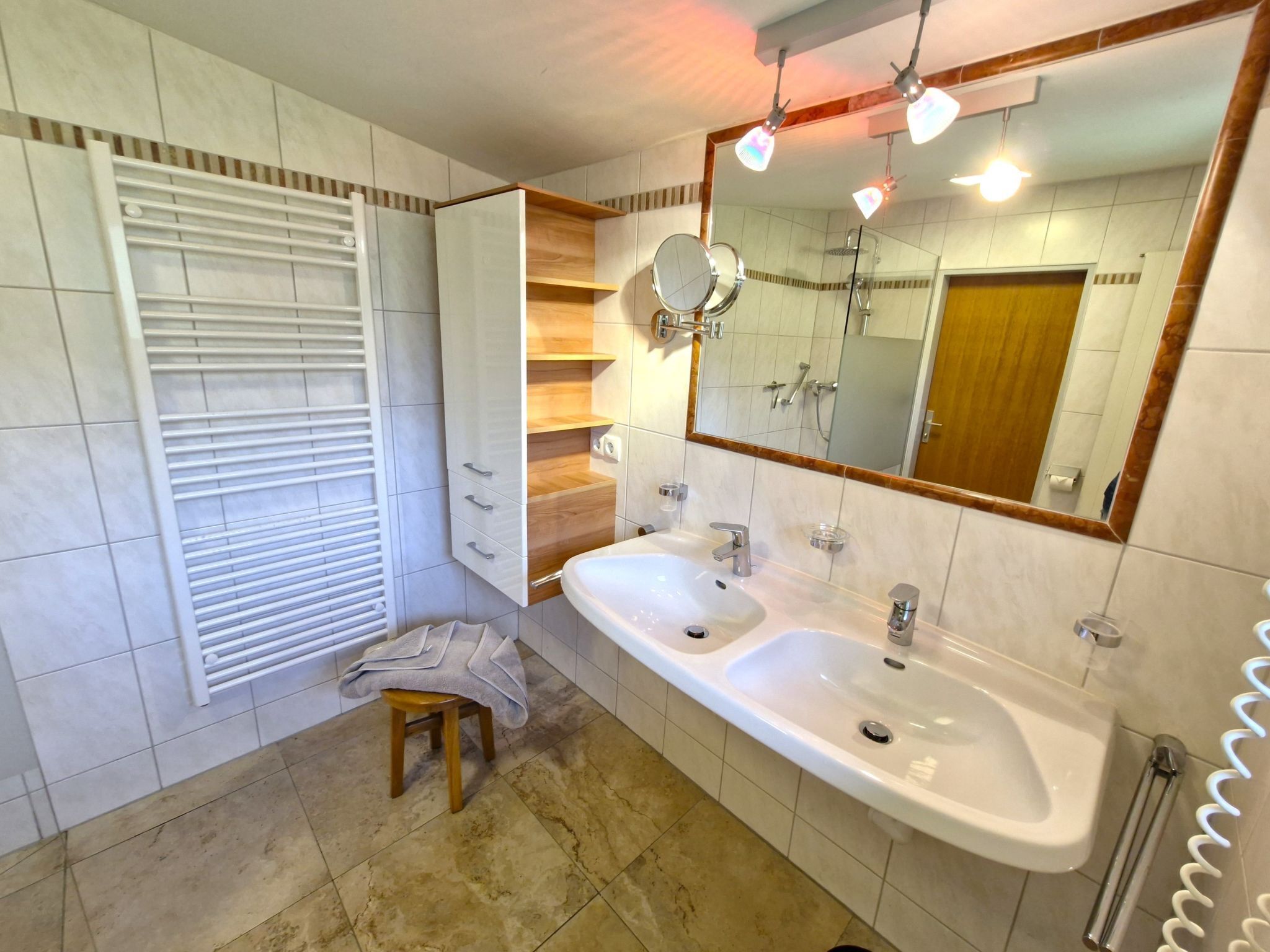 Une salle de bain avec deux lavabos, un miroir et un porte-serviettes.