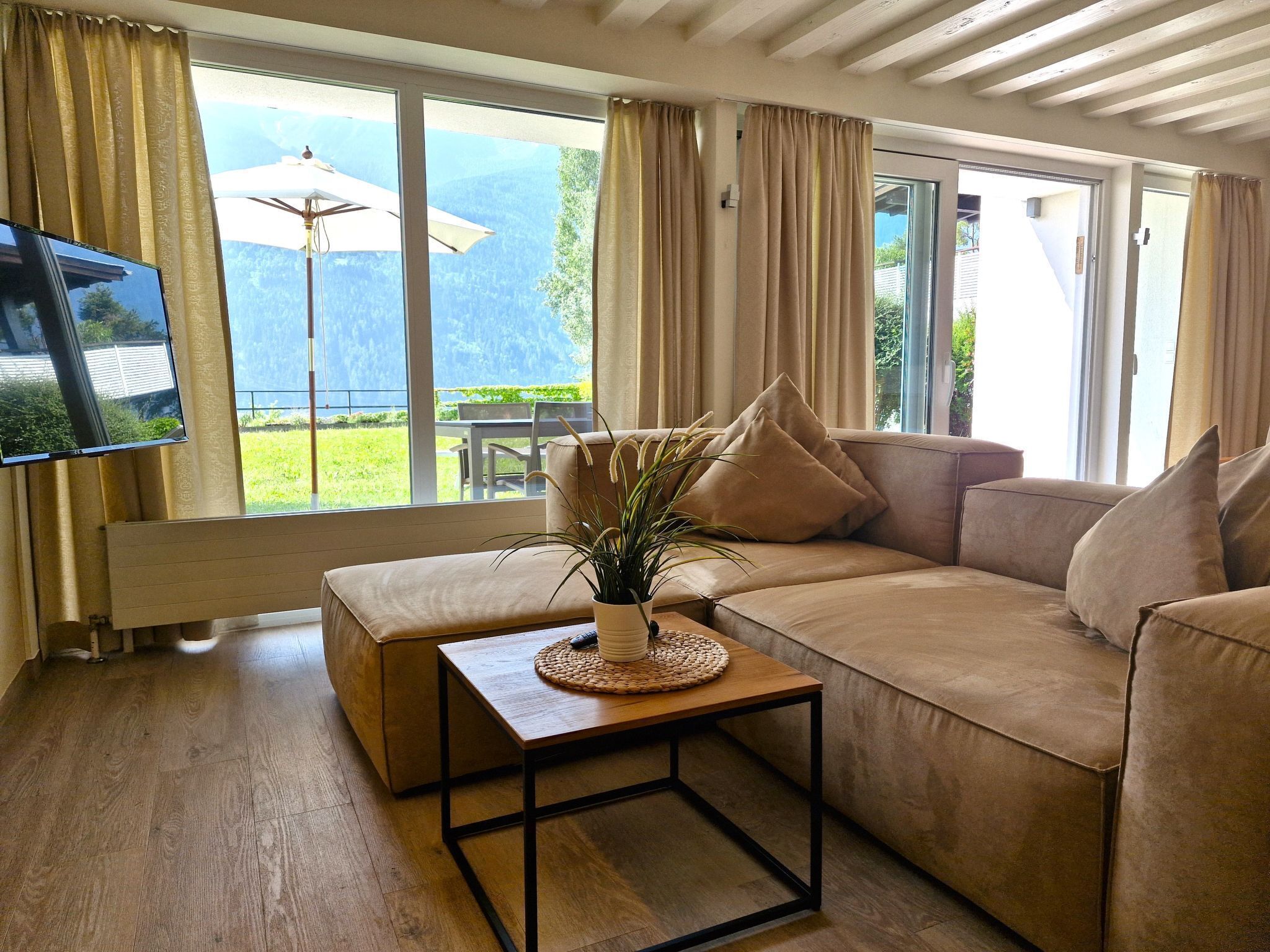 A living room with a sofa, a coffee table, and a TV.