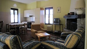 A living room with a sofa set, a coffee table, a television, and a fireplace. - Farmhouse in Verbania With Mountain Views (Verbania)