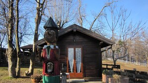 A rustic wooden cabin with a large wooden sculpture in front. - Cottage in Intra With Lake and Mountain Views (Verbania)