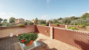A rooftop terrace with a brick floor, a lattice fence, and potted plants. - Apartment in Monte del Lago Near Lake Trasimeno (Magione)