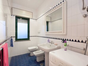 A bathroom with a toilet, bidet, sink, and mirror. - Belvilla by OYO Vesuvio (Trecase)