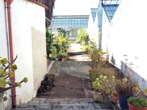 A narrow alleyway with potted plants and a building in the background. - Belvilla by OYO Vesuvio (Trecase)