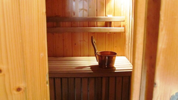 En träinredning med en metallkopp och en träsked på en hylla.