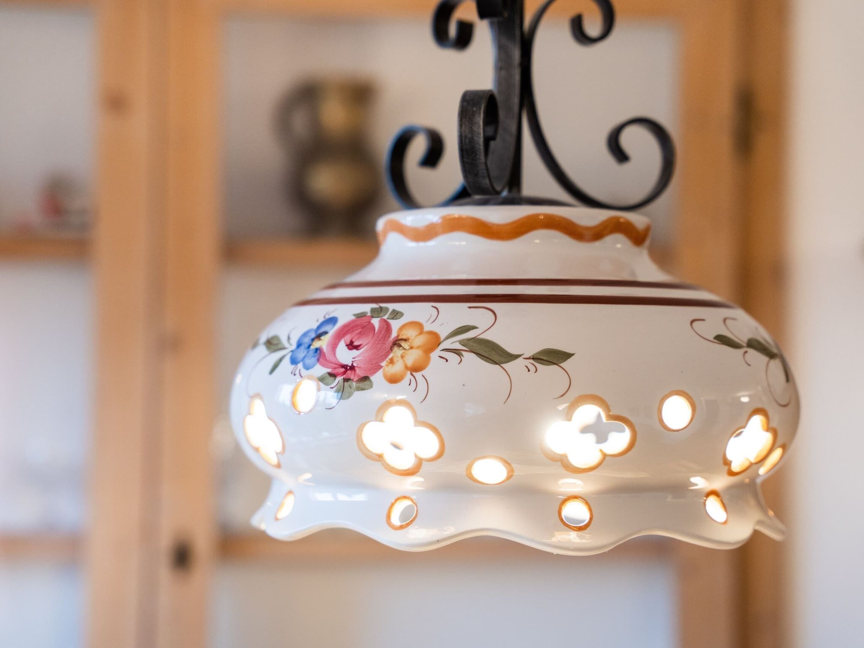 Eine dekorative Keramik-Leuchte mit floralen Mustern und mehreren Lampen.