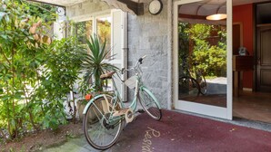Una bicicleta estacionada frente a un edificio con un felpudo rojo en la entrada.
