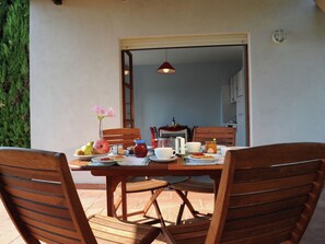 A wooden dining table with chairs, a vase of flowers, and various breakfast items. - Romantic Escape w/ Terrace (Centola)