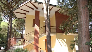 A two-story building with a staircase leading to a balcony. - Belvilla by OYO Elios Trilo Due (Rosolina)