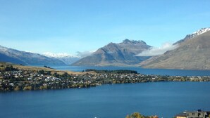 A lakeside town with a view of mountains and a clear sky.