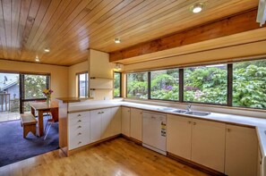 Enjoy meals in the kitchen with a view of lush greenery, featuring a dishwasher and ample countertop space.