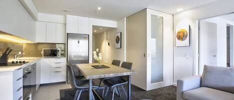 A modern apartment with a kitchen, dining area, and living room.