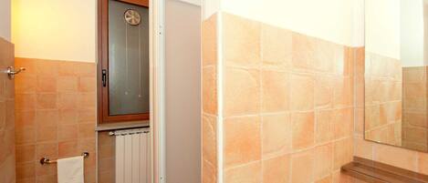 Un baño con inodoro, bidé y zona de ducha.