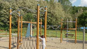 A playground with a rope bridge, climbing structures, and a slide. - Charming Tuscan Farmhouse (Ortignano Raggiolo)