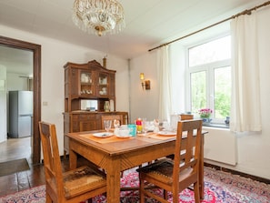 A dining area with a wooden table, chairs, a chandelier, a cabinet, and a window with a view. - Farm With Lovely Panoramic Views (Trois-Ponts)