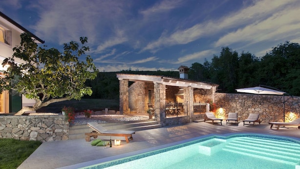 A swimming pool with lounge chairs and a stone structure with a pergola. - Attractive Villa With Private Swimming Pool, Beach Volleyball and Fenced Garden (Rasa)