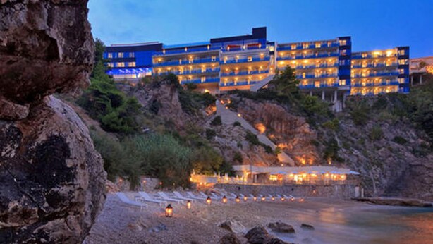 A multi-story hotel with a modern design, situated on a rocky hillside overlooking a beach. - Dubrovnik Coastal Gem (Dubrovnik)