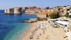 A coastal town with a historic fort, a sandy beach with sun loungers, and a clear blue sea. - Dubrovnik Coastal Gem (Dubrovnik)