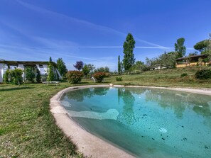A clear swimming pool with a concrete edge, surrounded by grass and trees. - Belvilla by OYO Casaletto Graffi (Graffignano)