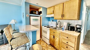 Cocina compacta con microondas, estufa y armarios de madera.