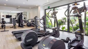 Un gimnasio con cintas de correr, elípticas y equipo de pesas.