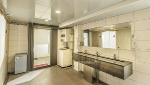 Un baño moderno con un espejo grande, un lavabo y una zona de ducha.