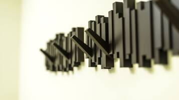 A modern, abstract sculpture with a series of black, rectangular shapes arranged in a staggered pattern against a light background.
