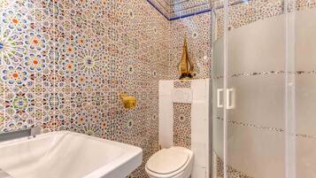 Une salle de bain avec une baignoire blanche, des toilettes et une cabine de douche en verre.