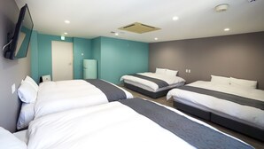 A hotel room with three beds, a flat-screen TV mounted on the wall, and a small refrigerator. - 88HOTELS (Matsuyama)
