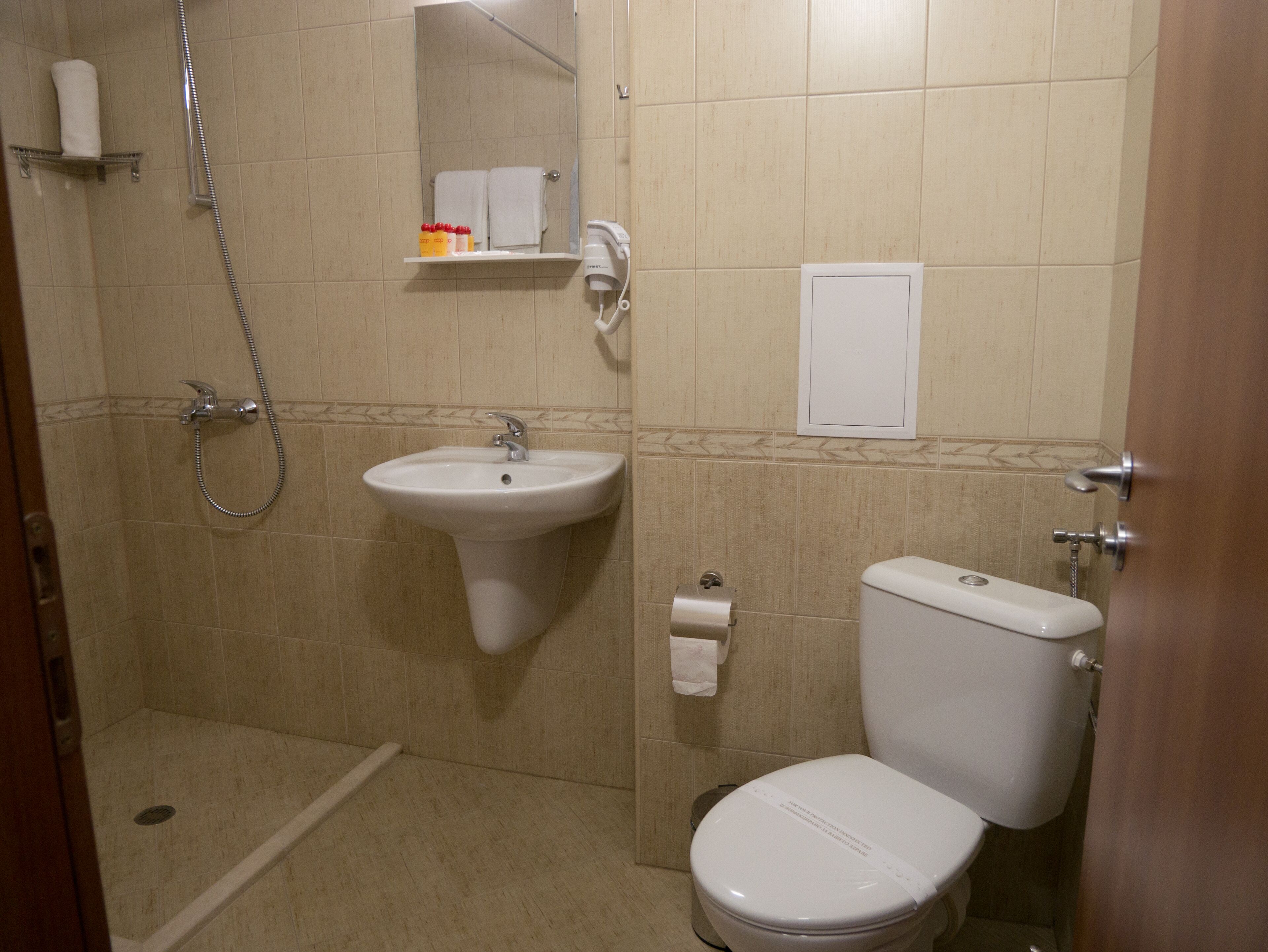 shower, hair dryer, towels, toilet paper