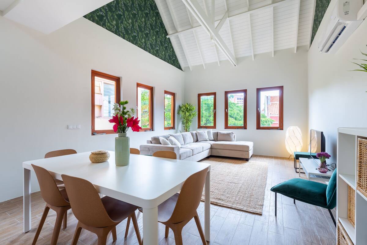 Un grand espace de vie comprenant une table à manger, des chaises, un canapé et un téléviseur.